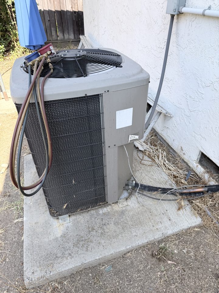 Refrigerant gauges connected to a home air conditioner condenser