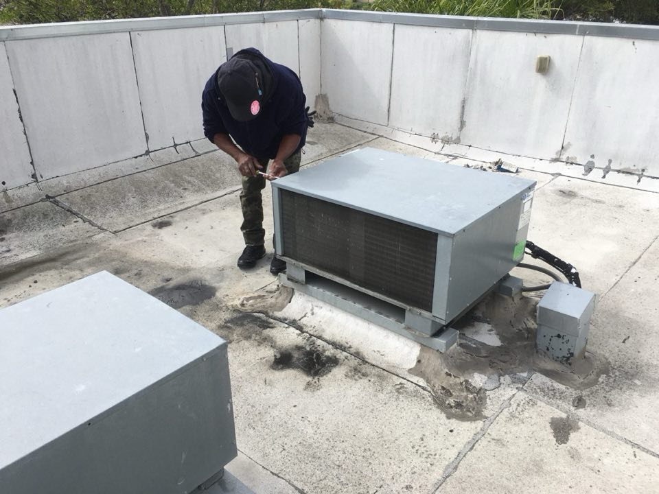 Cool Aid technician installing a rooftop condensing unit
