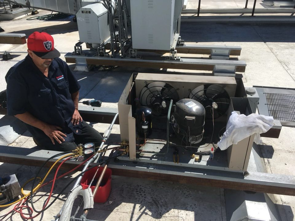 Cool Aid technician working on a refrigeration compressor unit